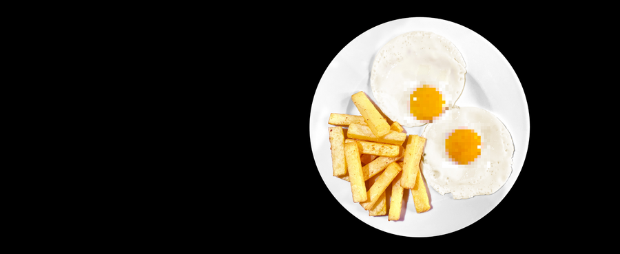 Two fried eggs on a white plate with French fries against a black background
